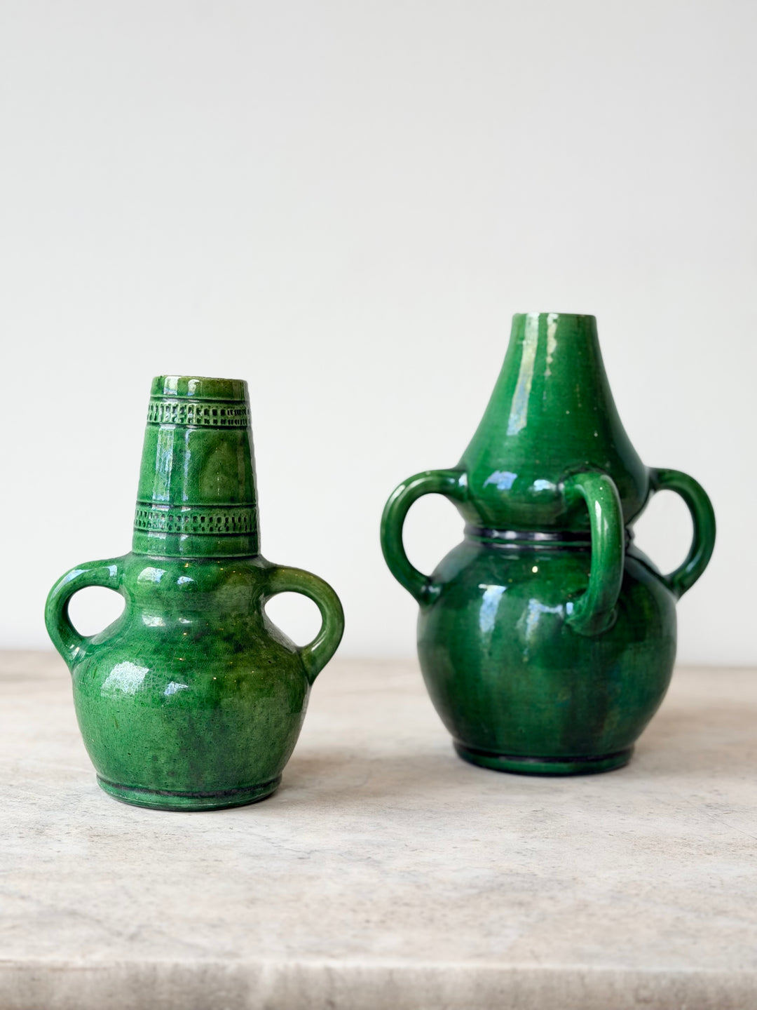 Pair of mid-20th century Belgian green glazed ceramic vessels with a glossy finish, designed by Housebound Interiors.