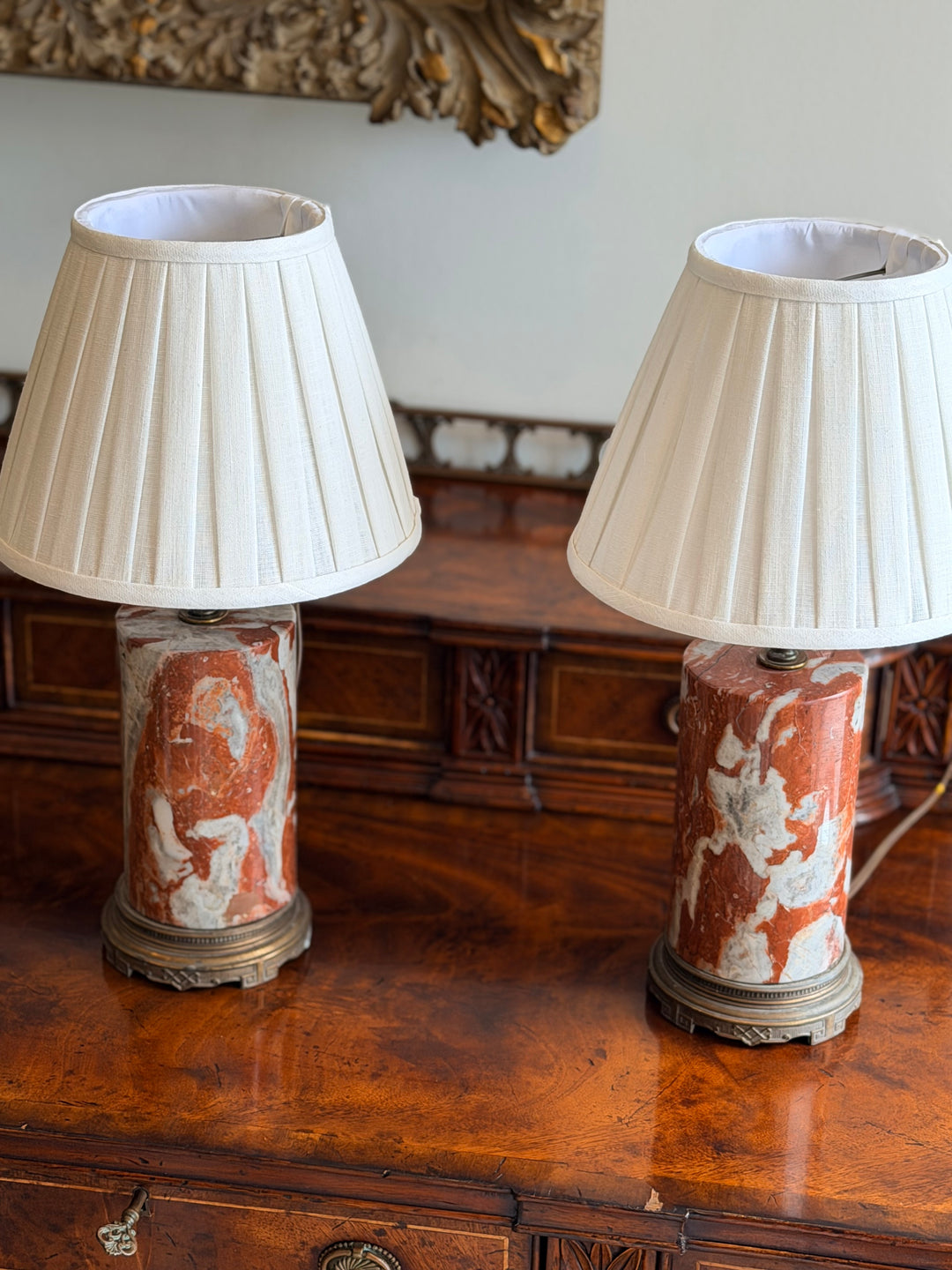 Italian marble column lamps in rouge and ivory with custom pleated shades, by Housebound Interiors.