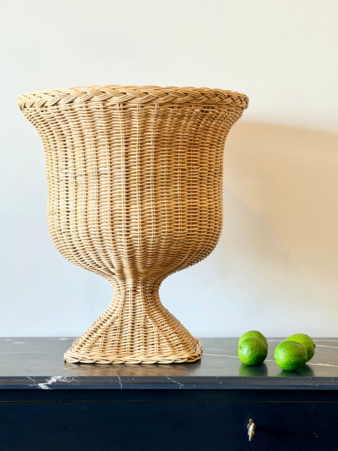 Woven rattan urn-shaped planter from Housebound Interiors, featuring a natural finish and sturdy design for indoor or outdoor use.