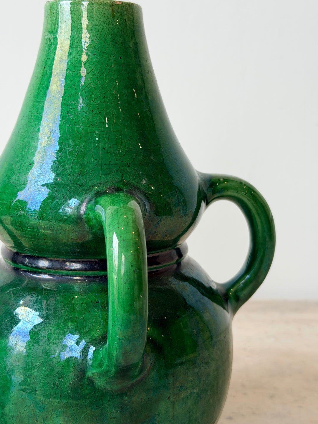 Pair of mid-20th century Belgian green glazed ceramic vessels with rounded shapes and decorative detailing, by Housebound Interiors.