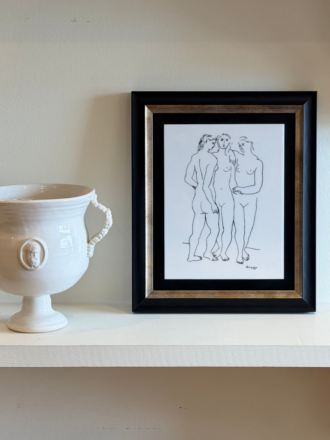 Colorful lithograph of Les Trois Grâces by Pablo Picasso from the 1970s, displayed in a frame on a wall.