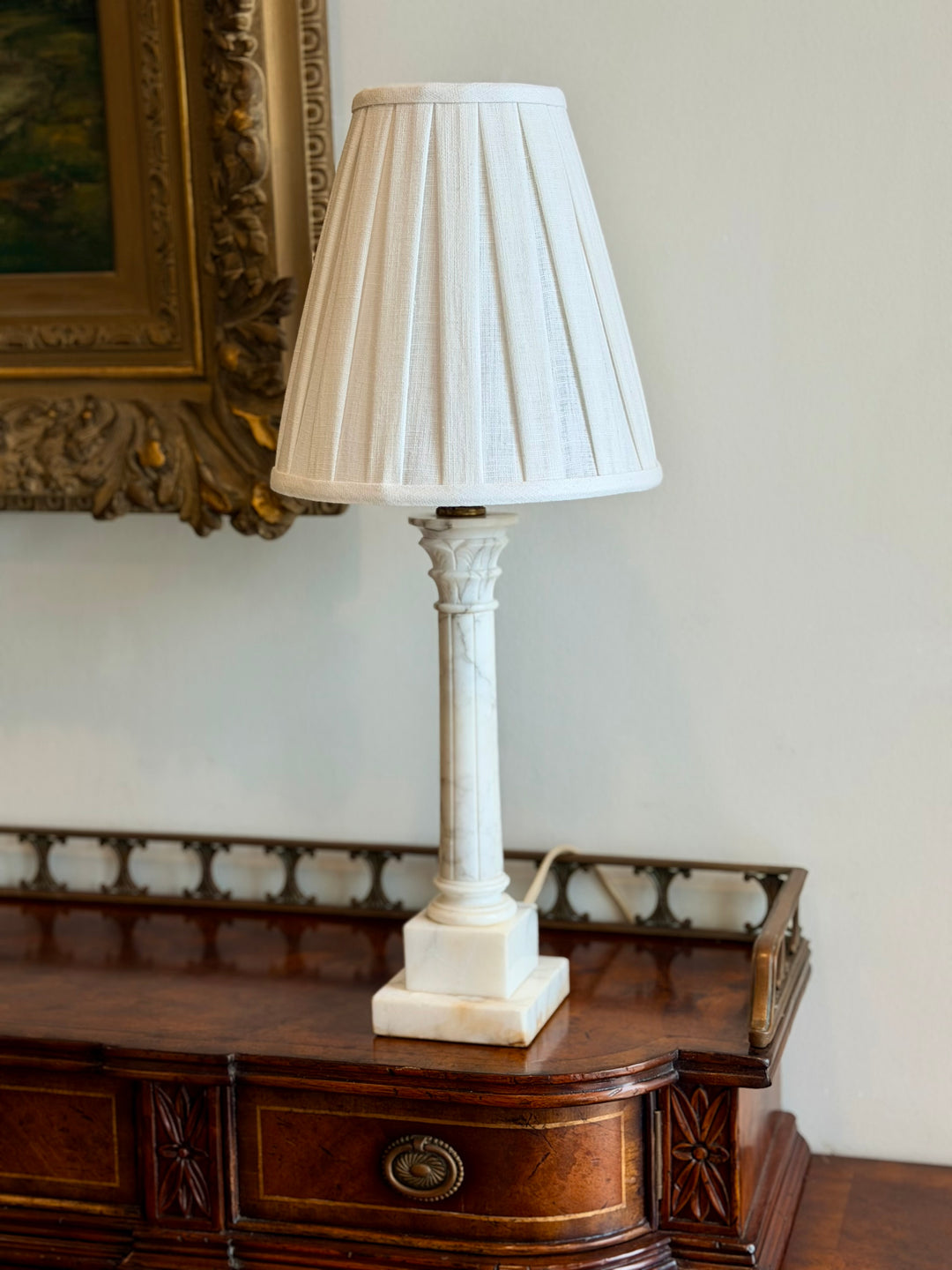 Small Italian marble column table lamp with a custom pleated fabric shade, elegant and decorative lighting for interior spaces.
