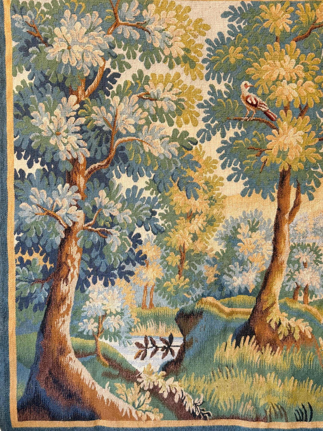 Early 20th century French verdure tapestry featuring birds and a serene countryside landscape.