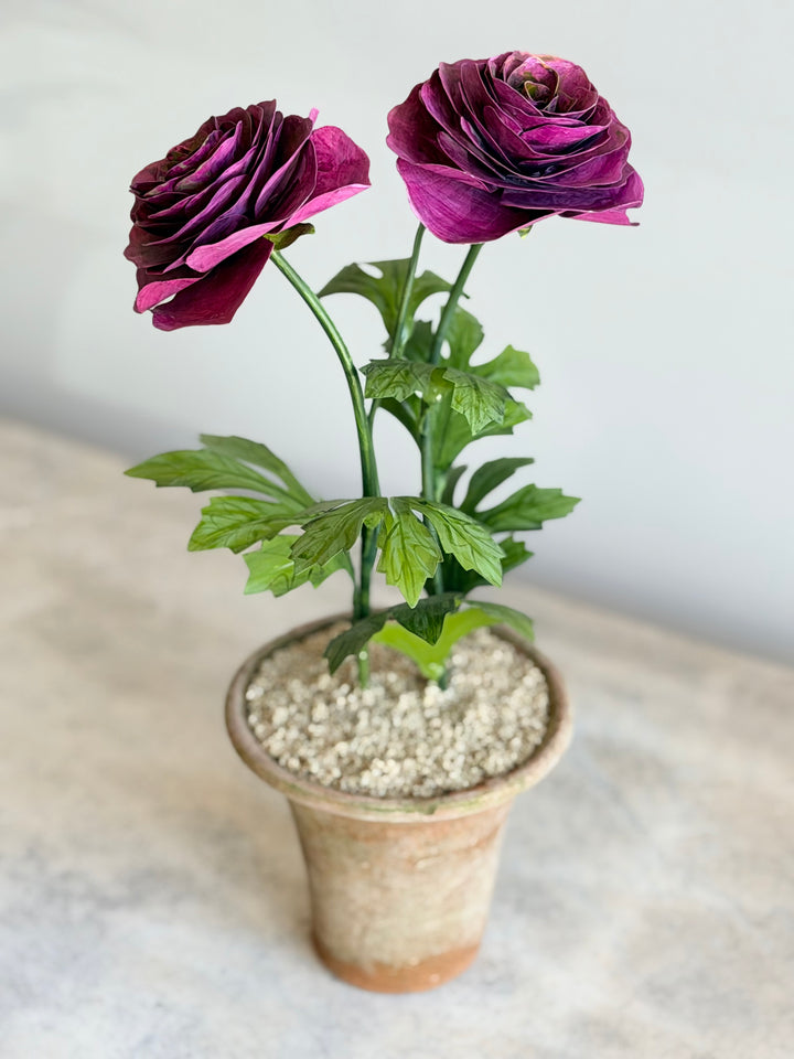 Ranunculus Tole sculpture in magenta, displayed in an aged terracotta pot, by Housebound Interiors.