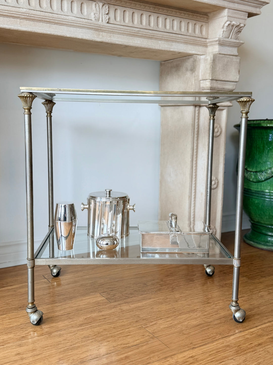 Neoclassical brass and chrome bar cart by Housebound Interiors, inspired by Maison Jansen, with glass shelves and vintage design