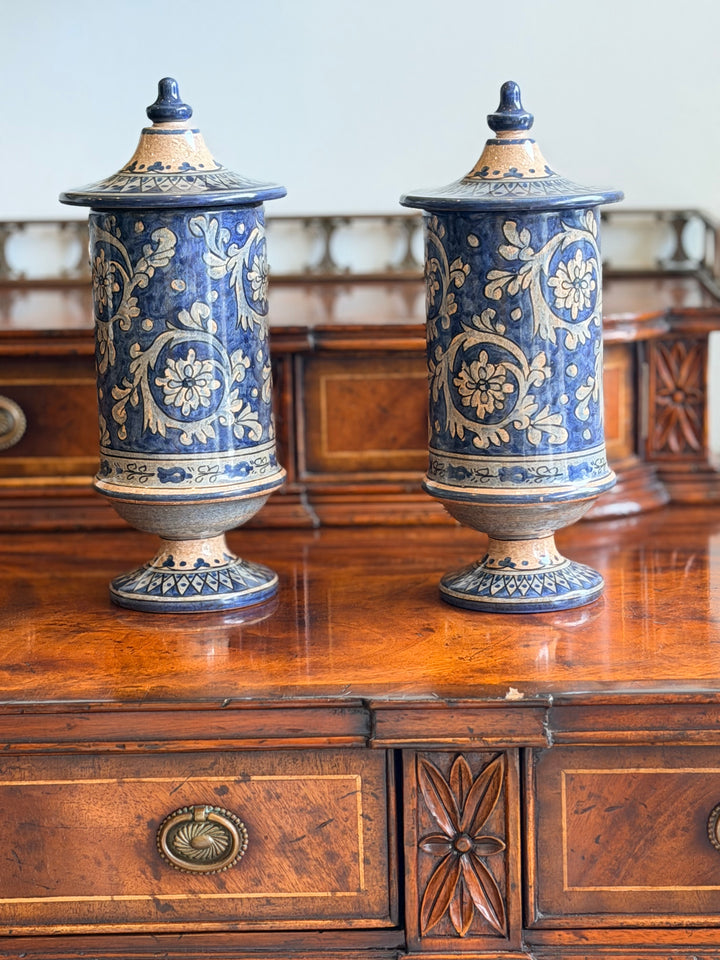 Pair of vintage Italian faience lidded urns with intricate blue and white floral designs, decorative ceramic storage containers.