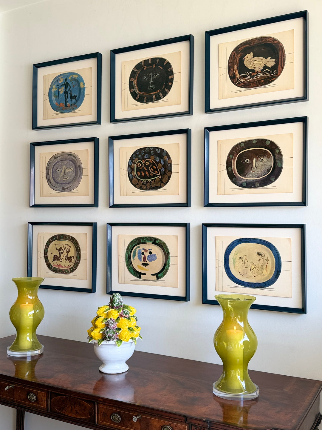 Nine tipped-in color lithographs from Picasso's Céramiques series, displayed in a vintage art collection, showcasing vibrant ceramic-inspired designs.