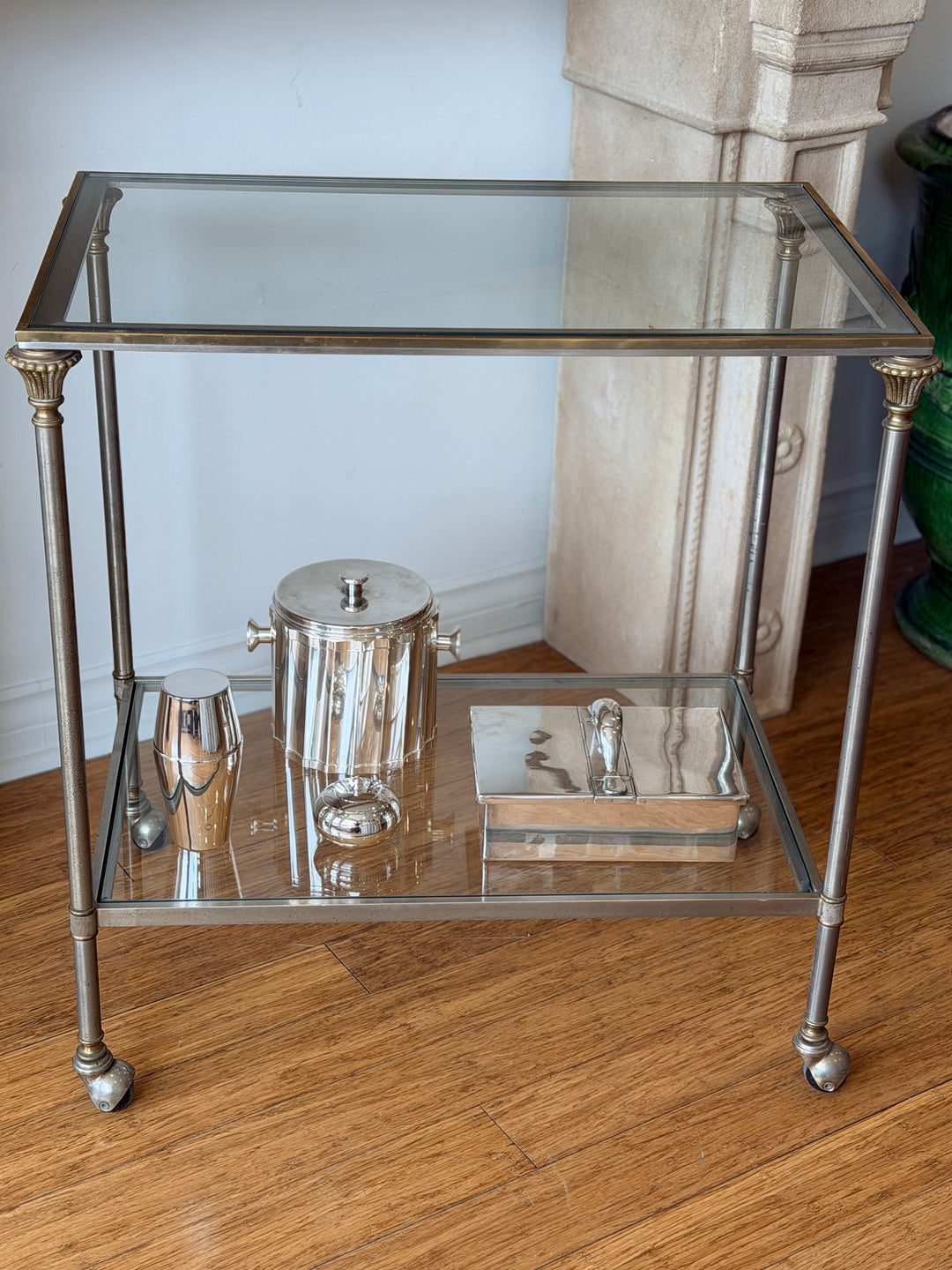 Neoclassical brass and chrome bar cart in vintage style, inspired by Maison Jansen, with multiple shelves and elegant design.