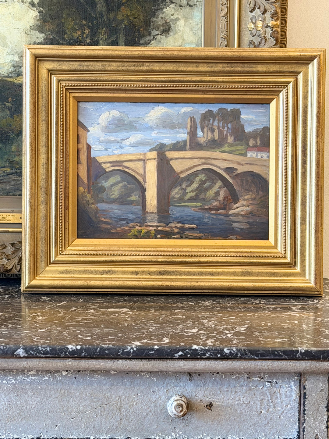 Early 20th-century oil on board landscape of a river bridge in a gilt frame, French Provincial style by Housebound Interiors.