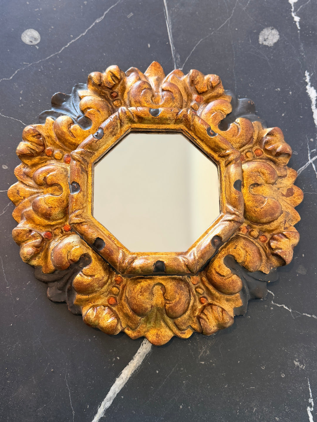 Antique Italian carved giltwood sunburst mirror with octagonal frame, detailed craftsmanship, ornate gold finish, decorative wall mirror