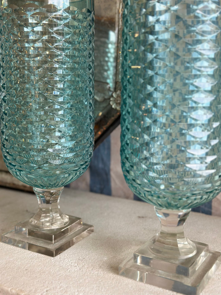 Pair of pale blue diamond-shaped glass hurricane candle holders by Housebound Interiors, with intricate geometric patterns.
