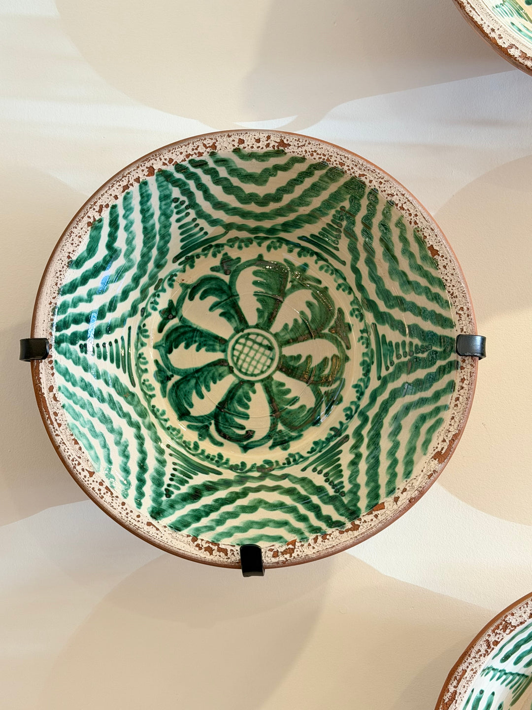Large Andalusian green glazed ceramic basin with hand-painted sun design by Housebound Interiors.